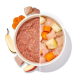 Vogelperspektive einer geteilten Futterschüssel: links feuchtes Hackfleisch, rechts gewürfeltes rohes Huhn mit Karotten- und Apfelstücken, Obstscheiben daneben.