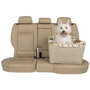Ein glücklicher weißer West Highland Terrier sitzt in einem beigen Autositz für Haustiere auf einem tanfarbenen Lederrücksitz, mit einem karierten Kissen.