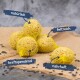 Fünf gelbe Netzvogel-Futterbälle auf einer Juteschicht, beschriftet mit "natürlich," "fettreich," "kraftspendend," und "nahrhaft."