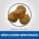 Vier runde Haustierfutterpellets, etwa 10,5 x 12,5 mm groß, auf einem hellen Hintergrund mit dem Text "Köstlicher Geschmack" darunter.
