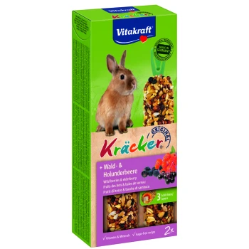 Ein brauner Kaninchen neben einer Box mit Vitakraft Kräcker, die Wildbeeren und Holunderleckereien enthält, mit den Aufschriften 'Vitamins & Minerals' und 'Zuckerfreies Rezept.'