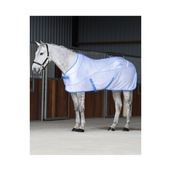 Ein graues Pferd mit einer weißen und blauen Pferde-Decke steht in einem Stall, mit sichtbaren Holzboxen im Hintergrund.