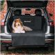Ein Colliehund entspannt sich auf einer schwarzen Autositzabdeckung im Rücksitz eines Autos, mit dem Text 'RUDELKÖNIG' auf der Abdeckung.