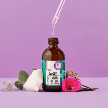 Braune Glasflasche mit dem Etikett '06 ZecOFF' und einer Pipette, umgeben von Blättern und Blumen auf einem lila Hintergrund.