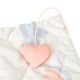 A close-up of a pet bed featuring a soft, quilted design with pastel colors and a pink heart-shaped toy attached by a cord.