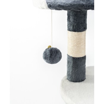 Eine Nahaufnahme eines Katzenbaums mit einem plüschigen grauen und weißen Design, mit einem hängenden grauen Pom-Pom-Spielzeug, das mit einem Band befestigt ist.