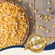 Eine Holzschüssel mit gelben Maiskörnern, einige verstreut, mit einem Abzeichen, das "Beste Qualität" und "Bewährte Qualität seit über 10 Jahren" besagt.