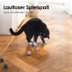 Eine schwarz-weiße Katze, die mit bunten Filzkugeln auf einem Holzboden spielt, mit dem Text "Lautloser Spielspaß dank dämpfendem Wollfilz" darüber.