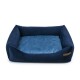 Navyblaue Hundebett mit plüschigen Seiten und einer weichen, hellblauen Schlafoberfläche, mit einem kleinen Holzschild an der Seite.