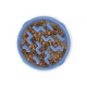 Eine blaue langsame Futter-Schüssel für Haustiere, gefüllt mit trockenem Hundefutter, mit Zickzack-Mustern, um langsameres Essen zu fördern.