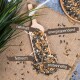 Eine Holzschaufel gefüllt mit Samen und Körnern, beschriftet mit "nahrhaft," "energiespendend," "fettreich," und "proteinhaltig," auf Jute mit Gras.