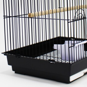 Schwarzes Vogelkäfig mit einem Holzstange und einer abnehmbaren Plastikfütterungsschale im Inneren, vor einem weißen Hintergrund.