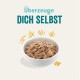 Schüssel mit Haustierfutter mit einer strukturierten Mischung, begleitet von dem Text "Überzeuge DICH SELBST" in fetter, verspielter Schrift.