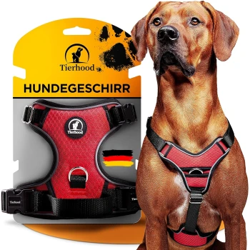 Schwarzes Hundegeschirr, das auf einer Verpackung mit dem Text "Tierhood HUNDEGESCHIRR" und einer deutschen Flagge präsentiert wird. Ein Hund trägt das Geschirr.