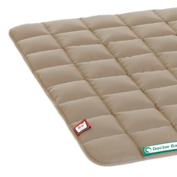 Beige Haustierbett mit einem gesteppten Design, mit einem kleinen rot-weißen Etikett und einem grünen Label, das "Doctor Bark" liest.