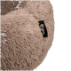Eine Nahaufnahme eines weichen, plüschigen Hundebetts in hellbeige, mit einem schwarzen Etikett mit dem Markennamen "Pawtastic."