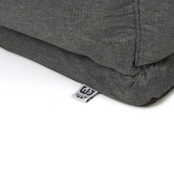 Graue Haustierbett-Ecke mit einem sichtbaren Etikett, das ein Logo zeigt. Der Stoff hat eine strukturierte Oberfläche.