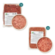 Verpackung für rohes Haustierfutter mit zwei vakuumverpackten Portionen Lammfleisch und einer Schüssel mit gehacktem Fleisch, beschriftet mit Nährwertinformationen.