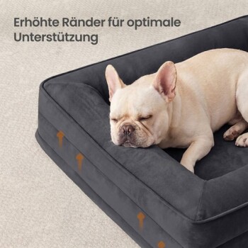 Cremefarbene Französische Bulldogge schläft auf einem dunkelgrauen, gepolsterten Haustierbett; deutscher Text „Erhöhte Ränder für optimale Unterstützung“ und orange Pfeile.