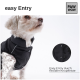 Ein kleiner, flauschiger Hund trägt eine schwarze Weste mit einem Kragen und zeigt das Feature "einfache Eingabe". Der Text hebt den flexiblen Knopfverschluss hervor.