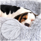 Ein schwarz-weißer Hund ruht auf einem flauschigen grauen Haustierbett, mit einer Nahaufnahme des weichen, zotteligen Stoffes in der Ecke.