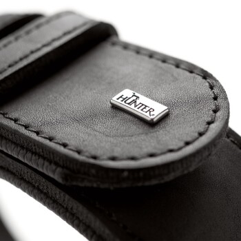 Nahaufnahme eines schwarzen Leder-Haustierhalsbandes mit einem silbernen "HUNTER"-Logoanhänger.