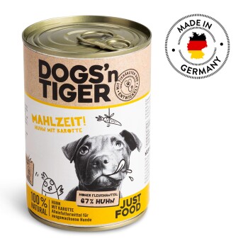 Dosenfutter für Hunde "DOGS'n TIGER" mit einem schwarzen Hund, der eine Karotte hält. Etiketten sagen "MAHLZEIT! Huhn mit Karotte," "100% NATURAL," "67% Huhn."