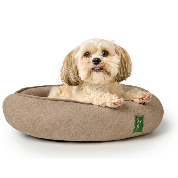 Ein kleiner Hund, der bequem in einem runden, beigen Hundebett mit einem grünen "Hunter"-Logo an der Seite ruht.