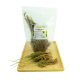 Getrocknete Hirsezweige in einer klaren Tüte mit dem Etikett "Rispenhirse - Rötkörnig" auf einem Holztablett, mit grünem Naturhintergrund.
