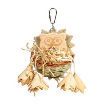 Holzhaustier-Spielzeug in einem geflochtenen Korb, mit einem Eulendesign und hängenden blumenförmigen Teilen, mit zerknülltem Papier im Inneren.