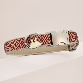 Stylische Hundehalsband mit einem rot- und cremefarbenen geometrischen Muster, silberner Schnalle und einem dekorativen Quastenanhänger.