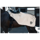 Ein braunes Pferd mit einer eleganten, glänzenden weißen Satteldecke mit dem schwarzen 'Equinate'-Logo, das in einer Stallumgebung steht.