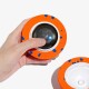 Hand hält einen orangefarbenen Schaumstoff-Haustierball mit blauen Punkten, inneres Elektronikmodul sichtbar und blau leuchtende LED.
