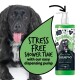 Ein schwarzer Hund mit einer rosa Zunge sitzt neben einer Flasche Bugalugs Aloe & Kiwi Shampoo, das "Stressfreies Duschen" mit einer einfach zu bedienenden Pumpe bewirbt.