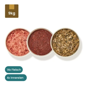 Tierfutterpakete mit vakuumverpackten Fleischprodukten und Schalen mit rohem Fleisch; Etiketten zeigen 16 Rind- und 2 Geflügelportionen mit Nährwertangaben.