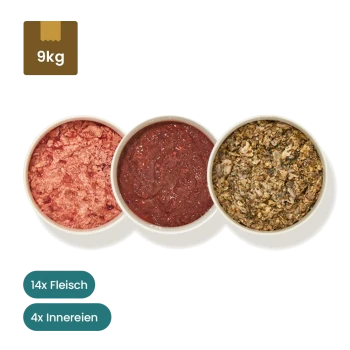 Tierfutterpakete mit vakuumverpackten Fleischprodukten und Schalen mit rohem Fleisch; Etiketten zeigen 16 Rind- und 2 Geflügelportionen mit Nährwertangaben.