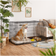 Ein glücklicher Hund sitzt in einer schwarzen Drahtkiste mit einem weichen Bett, umgeben von Pflanzen und einer gemütlichen Wohnzimmeratmosphäre.