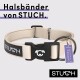 Beige Hundehalsband mit einer schwarzen Schnalle, das den Markennamen "STUCH" und ein lila Etikett mit der Aufschrift "PETA APPROVED VEGAN" trägt.