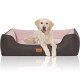Ein Golden Retriever Welpe ruht sich bequem auf einem stilvollen Hundebett mit dunklem grauen Äußeren und weichem rosa Innenraum aus.