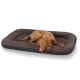 Ein brauner Hund liegt bequem auf einem plüschigen, dunkel gefärbten Haustierbett mit erhöhten Rändern.