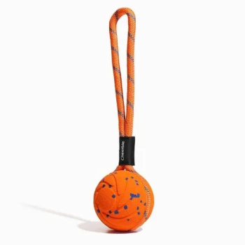 Oranger Hundeball mit blauen Sprenkeln, geflochtene orangefarbene Seilschlaufe und schwarzes Etikett mit der Aufschrift 'Cheerble'.