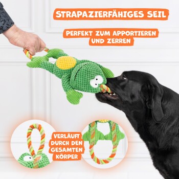 Ein schwarzer Hund zieht verspielt an einem grünen fischförmigen Seilspielzeug, das von einer Person gehalten wird. Text: "Haltbares Seil - Perfekt zum Apportieren und Ziehen."