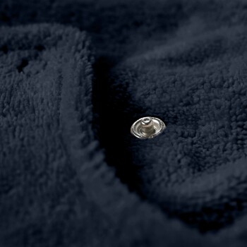 Nahaufnahme einer weichen, marineblauen Haustierdecke mit einem silbernen Druckknopf.