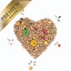 Herzförmige Anordnung verschiedener Samen und bunter Pellets, beschriftet mit "PREMIUM" in einem goldenen Banner.