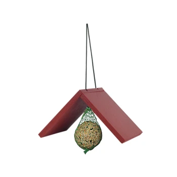 Rotes Vogelhaus aus Holz mit einer hängenden Samen-Kugel darin, aufgehängt an einer schwarzen Schnur vor weißem Hintergrund.