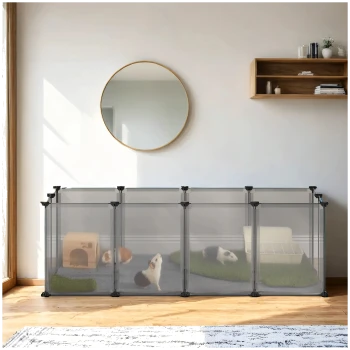Ein geräumiger Innenbereich für Haustiere mit drei Abschnitten, in dem zwei Meerschweinchen und ein Kaninchen auf grünem Gras, ein Holzhaus und eine weiße Katzentoilette zu sehen sind.