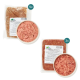 Haustierfutterverpackung mit zwei Fleischsorten: eine in einer Schüssel und zwei vakuumverpackte Beutel, beschriftet mit Nährwertinformationen.