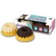 Twee kleurrijke hondensnacks in de vorm van mini bundt cakes naast een "Cheesie Curl!" doos met speelse graphics.
