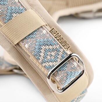 Nahaufnahme eines stilvollen Haustiergeschirrs mit beigem Grund und einem dekorativen Riemen mit blauen und cremefarbenen Mustern, gekennzeichnet mit "HEDOGIDEA".