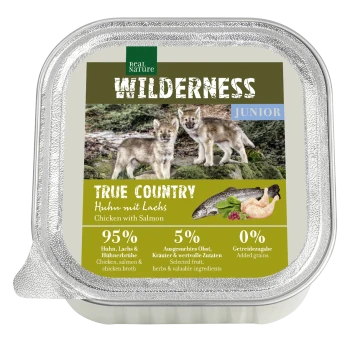 Verpackung für Nassfutter mit zwei Wolfwelpen, beschriftet "Wilderness Junior True Country Chicken mit Lachs," mit 95% Fleisch und 5% Früchten/Kräutern.
